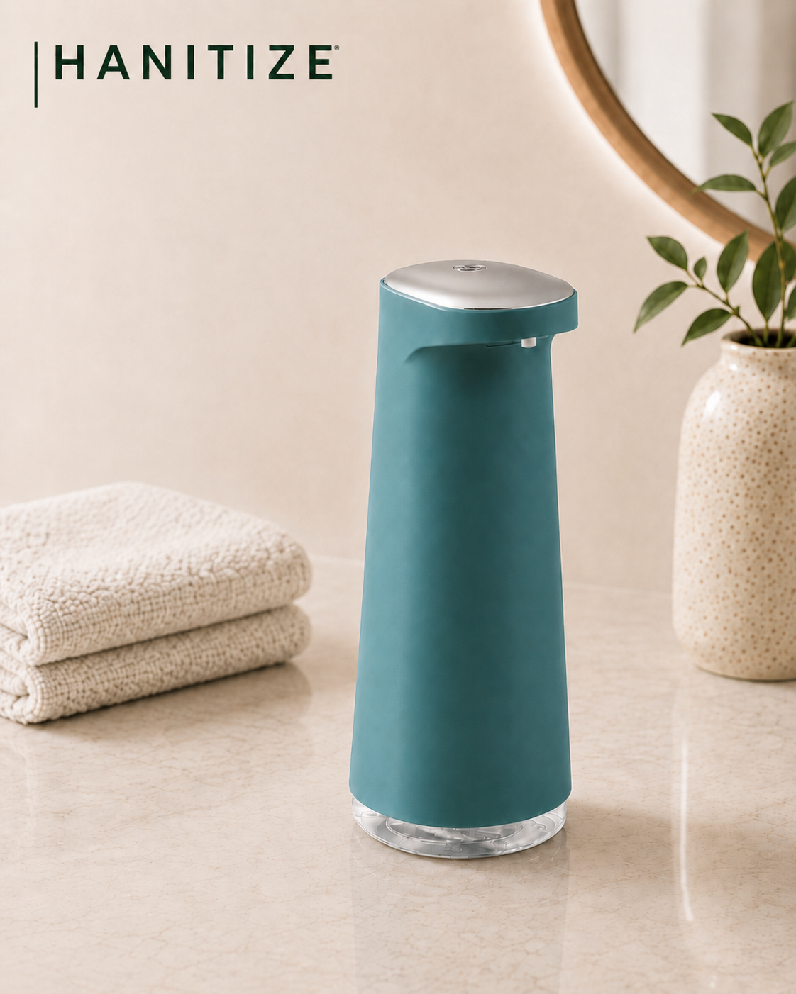 Teal Hanitize automatic soap dispenser on a modern bathroom countertop beside folded towels and a decorative plant.